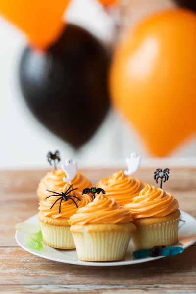 Pastelitos o magdalenas de fiesta de halloween en la mesa — Foto de Stock