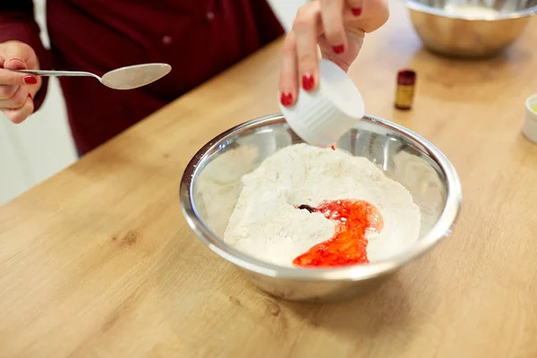 Manos de chef añadiendo color de comida en un tazón con harina —  Fotos de Stock