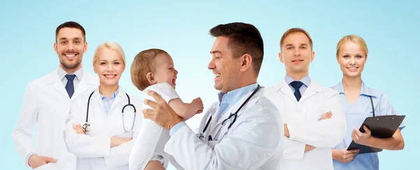Medico o pediatra felice con bambino sopra il blu — Foto Stock