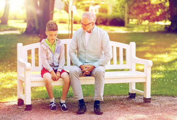Opa en kleinzoon aan het praten in het zomerpark — Stockfoto