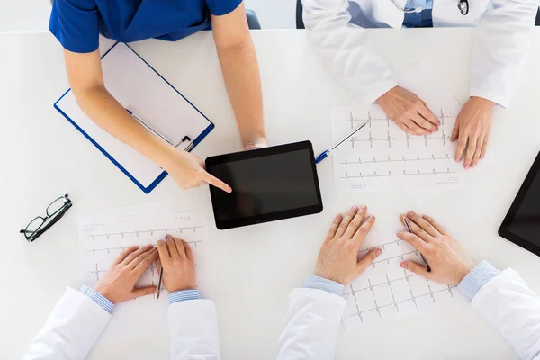 Ärzte mit Kardiogrammen und Tablet-PC im Krankenhaus — Stockfoto