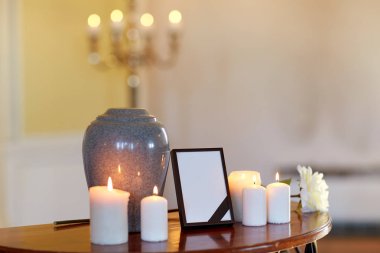 photo frame, cremation urn and candles in church clipart