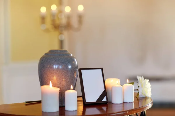 Photo frame, cremation urn and candles in church — Stock Photo, Image