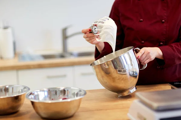 Šéfkuchař s rozšleháme a našlehaných bílcích v kuchyni — Stock fotografie