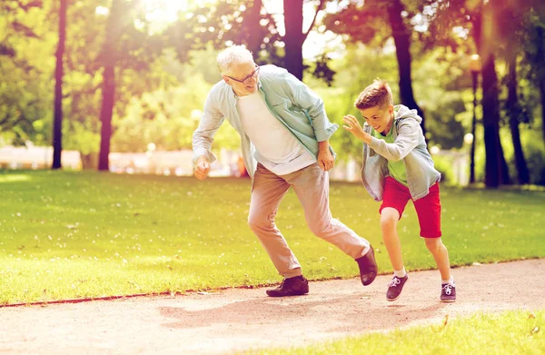 Abuelo y nieto corriendo en el parque de verano — Foto de Stock