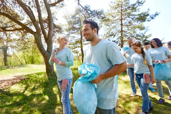 Volontärer med soppåsar promenader utomhus — Stockfoto