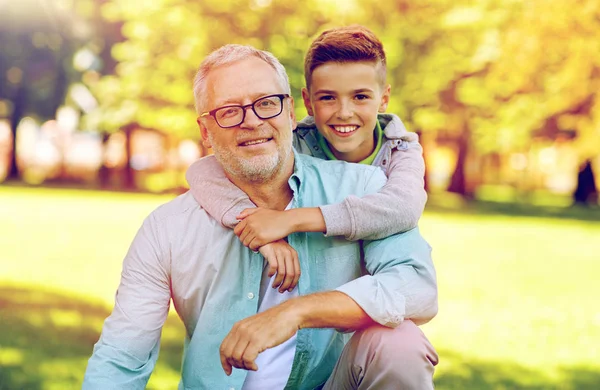 Дедушка и внук обнимаются в летнем парке — стоковое фото