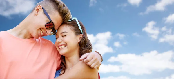 Feliz pareja adolescente abrazándose sobre el cielo azul — Foto de Stock