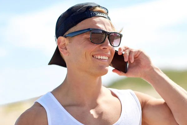 Homme souriant appelant sur smartphone sur la plage d'été — Photo