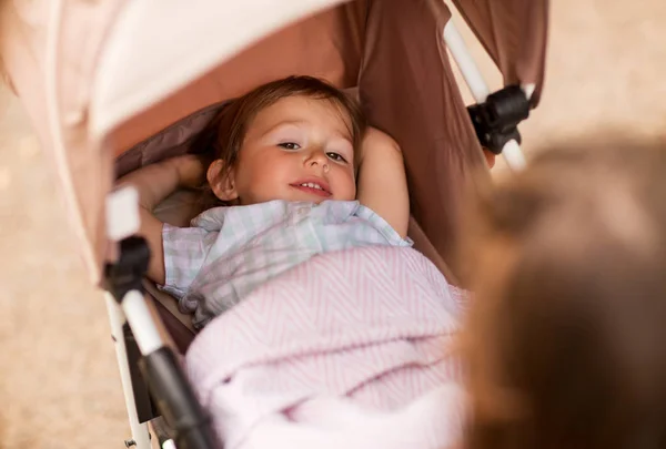 Little child or baby lying in stroller outdoors — Stock Photo, Image