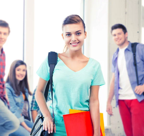 Studentka s školní tašku a barevné složky — Stock fotografie