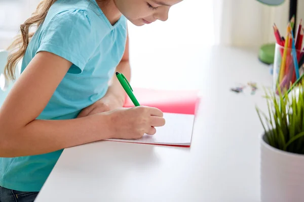 Menina feliz escrevendo para notebook em casa — Fotografia de Stock