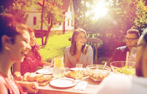 Ευτυχείς φίλοι έχοντας το γεύμα στο καλοκαιρινό πάρτι στον κήπο — Φωτογραφία Αρχείου