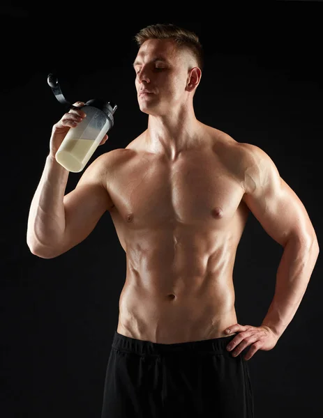 Young man or bodybuilder with protein shake bottle — Stock Photo, Image