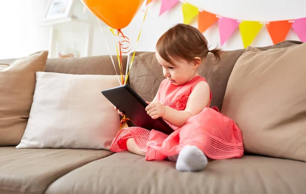 Baby girl with tablet pc on birthday party at home — Stock Photo, Image