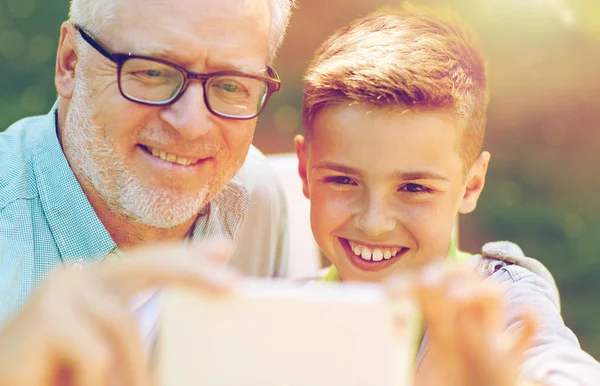 Old man and boy taking selfie by smartphone — Stock Photo, Image