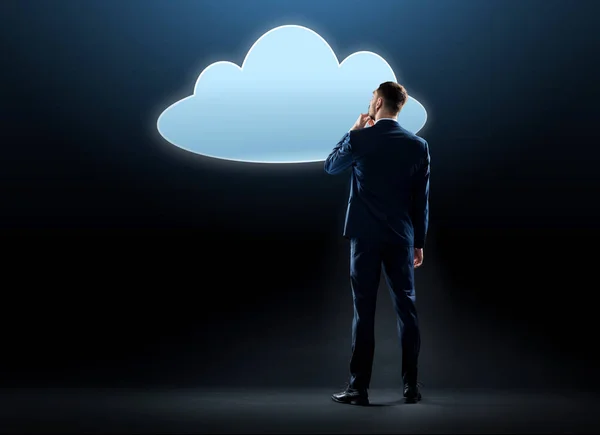 Бизнесмен смотрит на виртуальную облачную голограмму — стоковое фото
