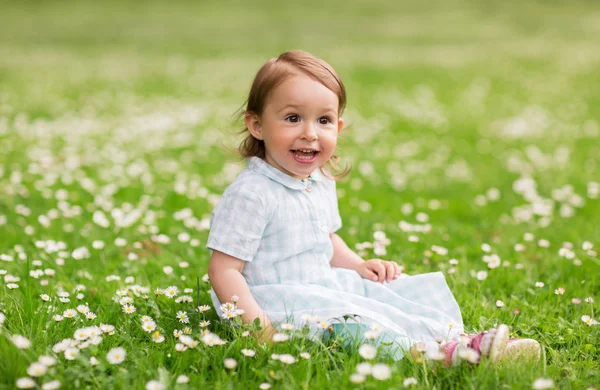 Happy baby girl on green summer field — Stock Photo, Image