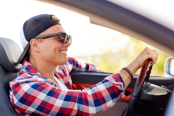 Gelukkig jongeman in tinten converteerbare auto rijden — Stockfoto