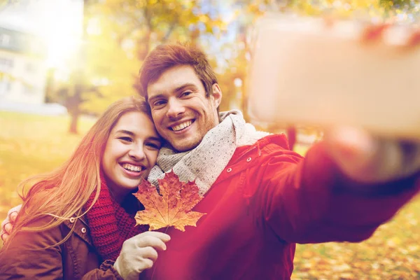 Casal tirando selfie por smartphone no parque de outono — Fotografia de Stock