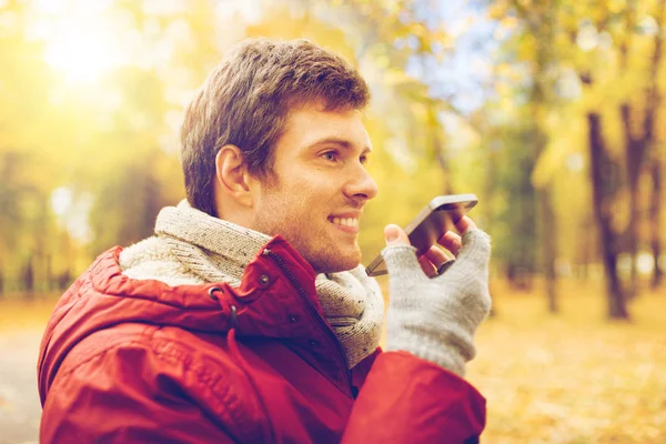 Mann nimmt Stimme auf Smartphone im Herbstpark auf — Stockfoto