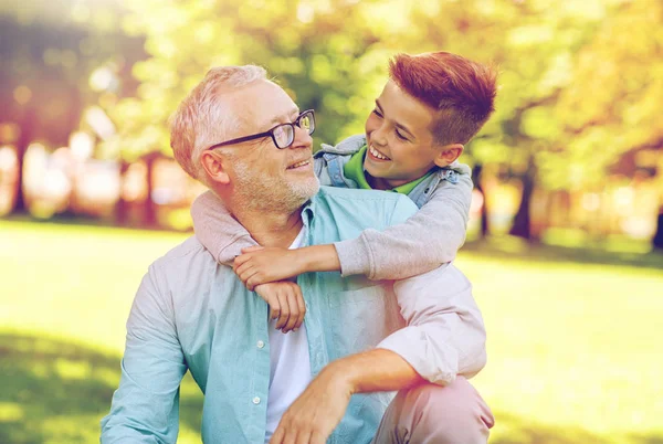 Abuelo y nieto abrazándose en el parque de verano —  Fotos de Stock