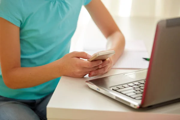 Girl with laptop and smartphone texting at home — Stock Photo, Image