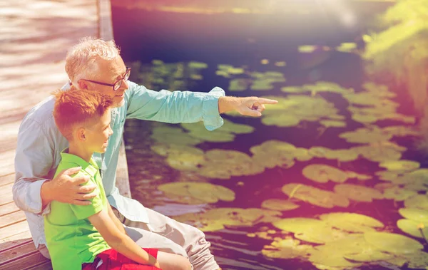 Abuelo y nieto sentado en la litera del río —  Fotos de Stock