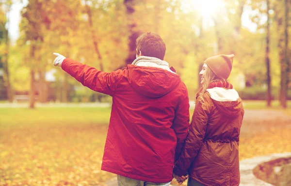 Felice giovane coppia a piedi nel parco autunnale — Foto Stock