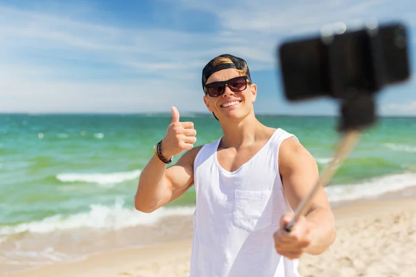 Mannen med smartphone tar selfie på sommaren beach — Stockfoto