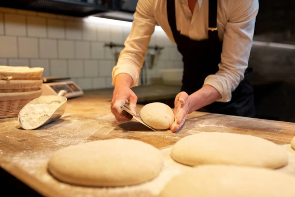 Baker, porcování těsta s stolní fréza v pekárně — Stock fotografie