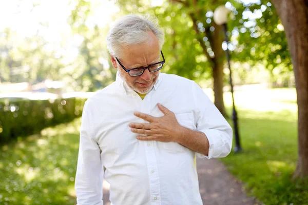 Idősebb ember érzi a beteg a nyári park — Stock Fotó