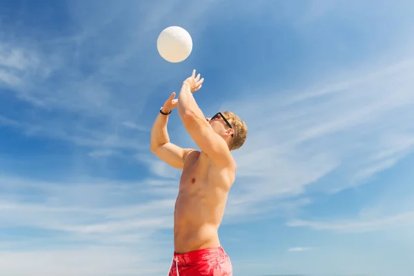 Junger Mann mit Ball spielt Volleyball am Strand — Stockfoto