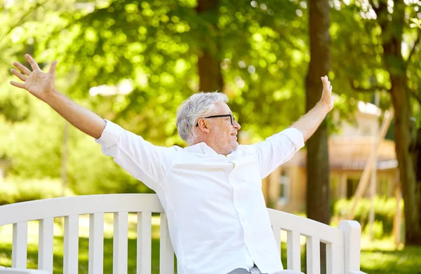 Heureux homme âgé assis sur le banc au parc d'été — Photo