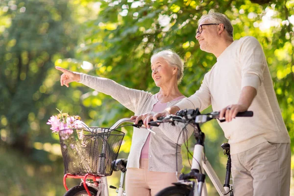 Feliz casal sênior com bicicletas no parque de verão — Fotografia de Stock