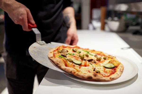 Koken met gebakken pizza op peel in pizzeria — Stockfoto