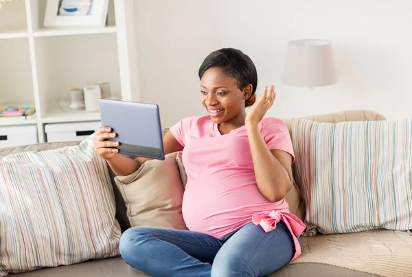 Mujer embarazada feliz con la tableta PC en casa —  Fotos de Stock