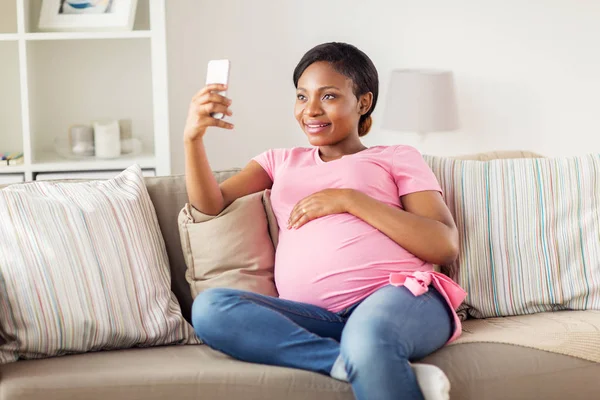 Femme enceinte prenant smartphone selfie à la maison — Photo