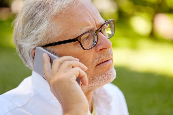 Homem sênior em óculos chamando no smartphone — Fotografia de Stock