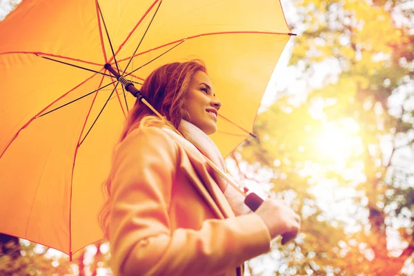 Donna felice con ombrellone passeggiando nel parco autunnale — Foto Stock