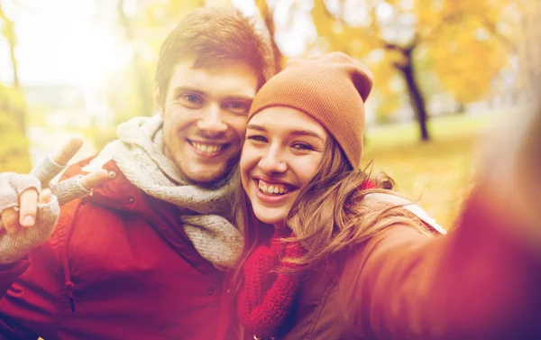 Feliz joven pareja tomando selfie en otoño parque —  Fotos de Stock