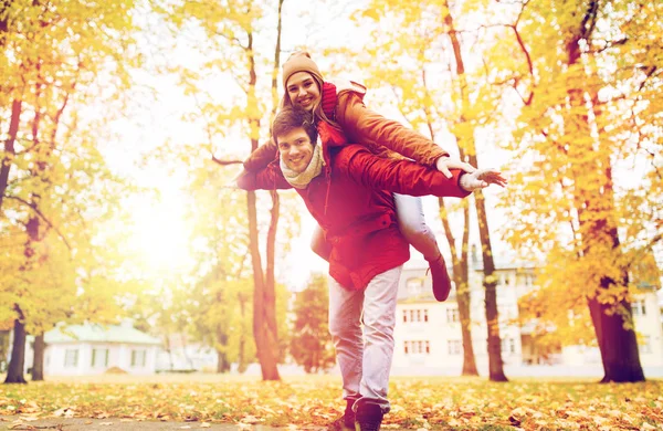 Feliz jovem casal se divertindo no parque de outono — Fotografia de Stock