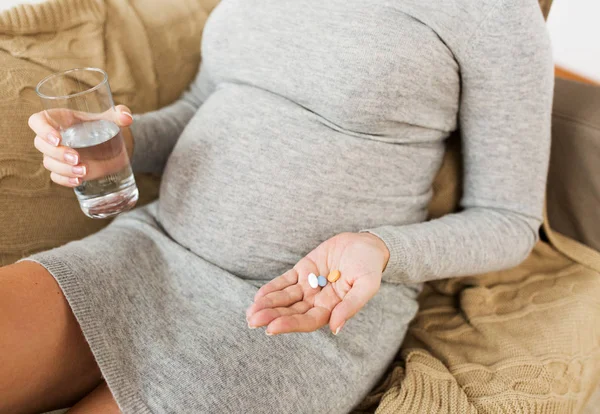 Närbild av gravid kvinna med piller hemma — Stockfoto