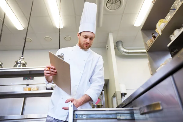 Chef con portapapeles haciendo inventario en la cocina — Foto de Stock