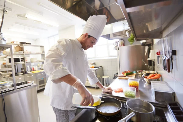 Feliz chef masculino cocina comida en la cocina del restaurante —  Fotos de Stock