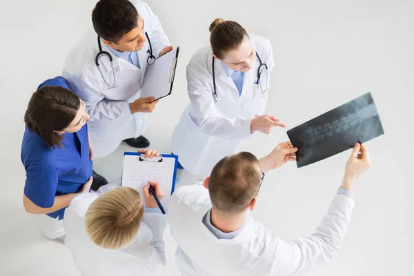 Ärzte mit Wirbelsäulenröntgen und Klemmbrettern — Stockfoto