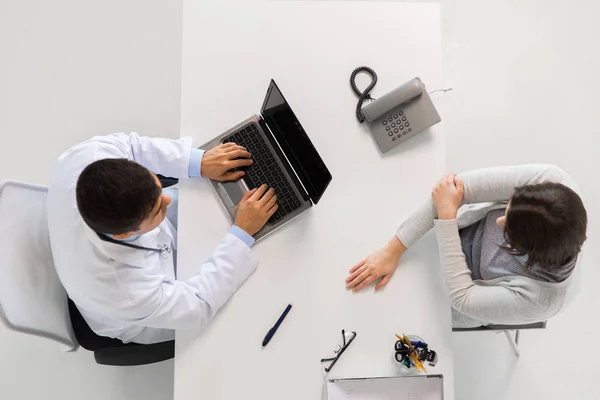 Läkare med laptop och kvinna patient på sjukhus — Stockfoto