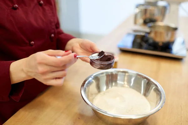 Mani dello chef aggiungendo colore alimentare in ciotola con farina — Foto Stock