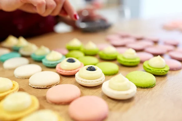 Chef decorating macarons shells at pastry shop — Stock Photo, Image