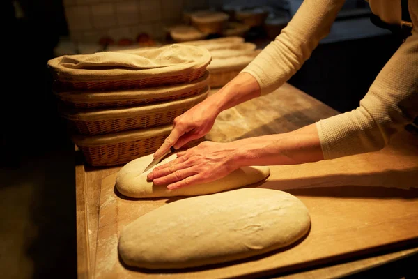 Шеф-повар или пекарь с тестом, готовящим хлеб в пекарне — стоковое фото